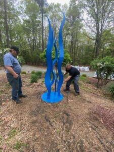 Custom decorative blue steel sculpture installation in residential yard